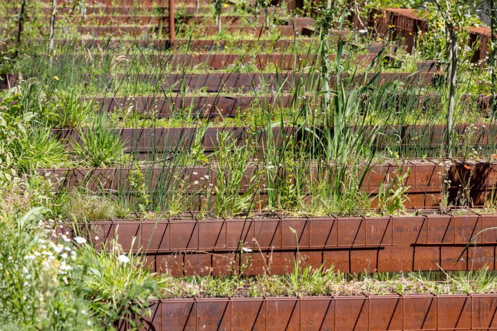 Groene planten en bomen groeien op de tijdelijk geplaatste damwanden